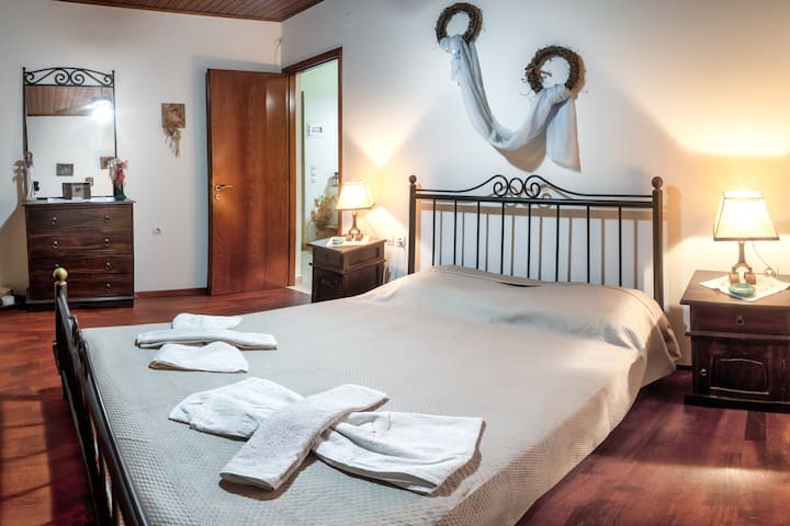 ห้องนอนใหญ่มีเตียงนอนสบายๆมีเสน่ห์แบบชนบทและแสงไฟอ่อนๆ