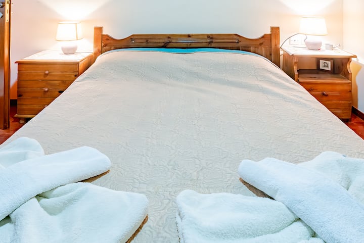 เตียงคู่ที่อบอุ่นพร้อมผ้าปูที่นอนนุ่มๆแสงอบอุ่นและบรรยากาศที่ผ่อนคลายสำหรับการพักผ่อนยามค่ำคืน