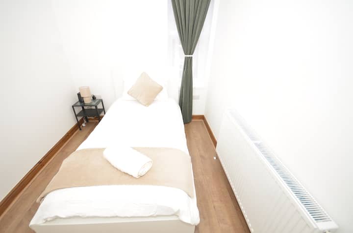 Dormitorio individual en el primer piso con baño compartido en la planta baja