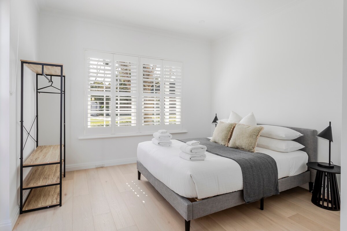 חדר שינה 5 - למטה עם מיטת קווין סייז, מרחב תלייה וגישה לחצר. 