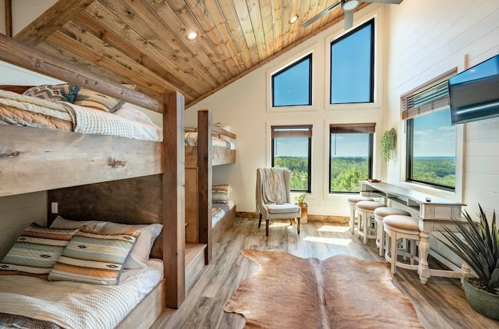 Bedroom with wood bunk beds, large windows, and scenic views