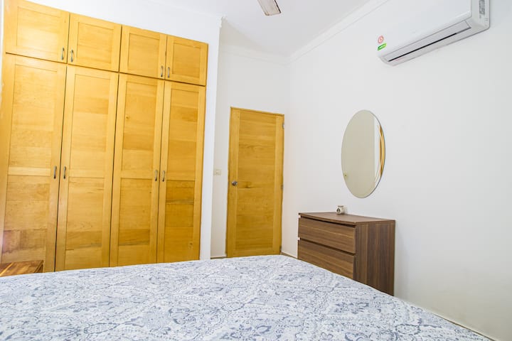 Dormitorio con cama matrimonial junto a espejo circular