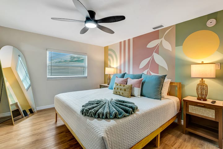 Светла и привлекателна основна спалня с голямо двойно легло, уютно спално бельо и ръчно рисувана стенна картина. Разполага с огледало в цял ръст, както и нощни лампи с вградени USB и USB-C портове за зареждане на личните ви устройства.