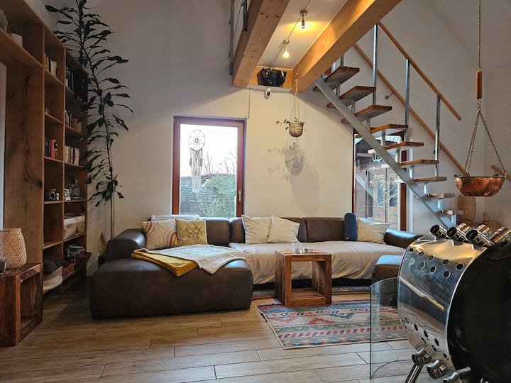 Dnevni boravak s vrlo velikim kaučem, kaminom i pametnim televizorom koji se može povećati (ovdje nije prikazan).