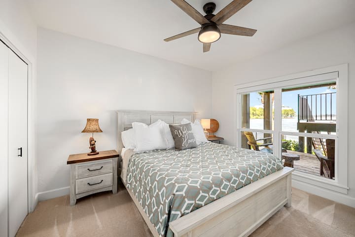 Acogedor dormitorio en la planta baja con una cama tamaño king, TV inteligente y vistas tranquilas al lago para despertarse.