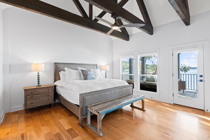 Despiértate con vistas serenas al lago en este dormitorio luminoso y espacioso con una cama tamaño king y techos abovedados