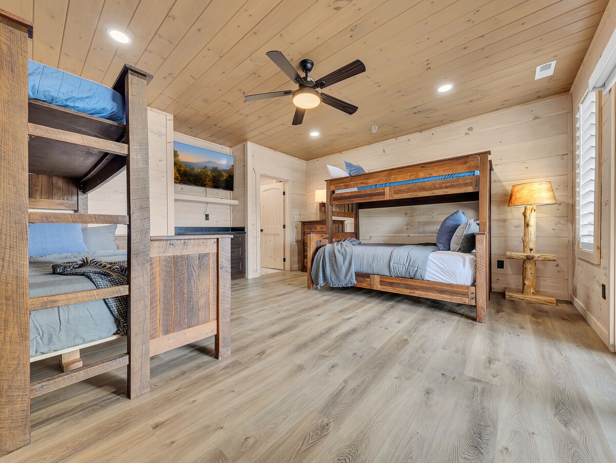 Rustikalni drveni kreveti, topla rasvjeta i moderni sadržaji stvaraju prostor za spavanje u planinskom stilu koji će se svima svidjeti.