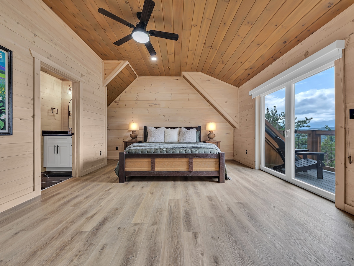 Ova udobna spavaća soba na katu spaja rustikalni dizajn s udobnošću, nudeći izravan pristupitak na balkon i beskrajne pogled na Smoky Mountain izravno iz vašeg kreveta.