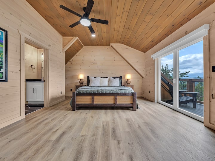 חדר השינה הנוח הזה שבקומה העליונה משלב עיצוב כפרי עם נוחות, ומציע גישה ישירה למרפסת ונופים אינסופיים של הרי הסמוקי היישר מהמיטה.