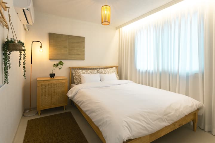 Este es un dormitorio privado donde la luz natural penetra suavemente.
Una cama tamaño queen, ropa de cama de calidad hotelera, muebles de madera cálida y una iluminación sutil se combinan para proporcionar un descanso cómodo. Es un dormitorio acogedor con cortinas opacas y un ambiente tranquilo que es ideal para un sueño profundo y un día completo de descanso.