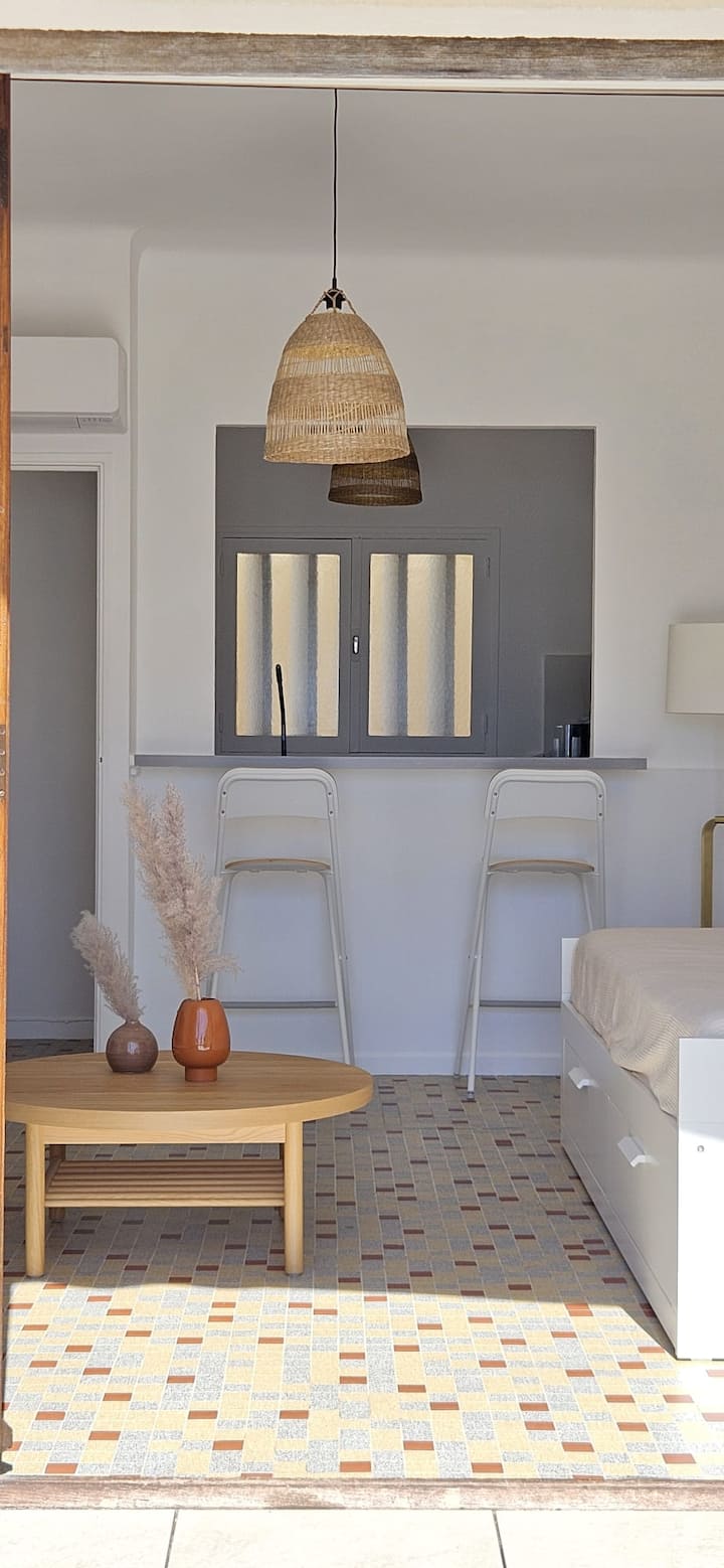 ห้องนั่งเล่นที่สว่างไสวพร้อมวิวทะเล มีเตียงโซฟาคู่ ทีวีที่เชื่อมต่อกัน โต๊ะกาแฟ และการตกแต่งที่ได้รับแรงบันดาลใจจากบลูโคสต์เพื่อให้บรรยากาศอบอุ่นและเป็นแบบฉบับ