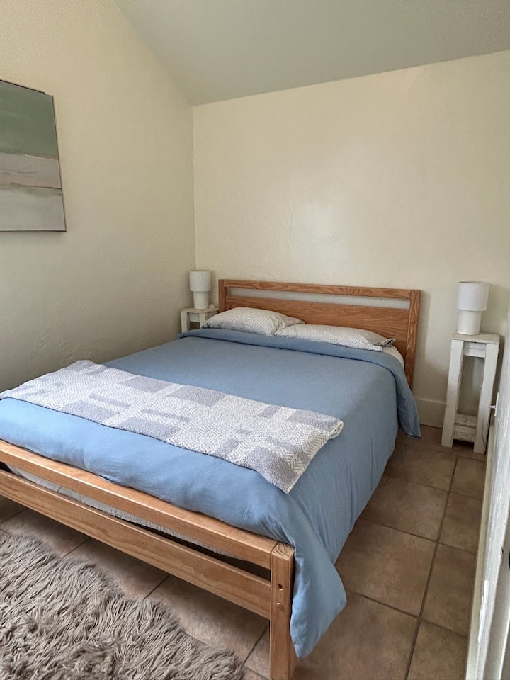 Cómoda cama de tamaño completo con una cálida decoración, perfecta para un retiro tranquilo.