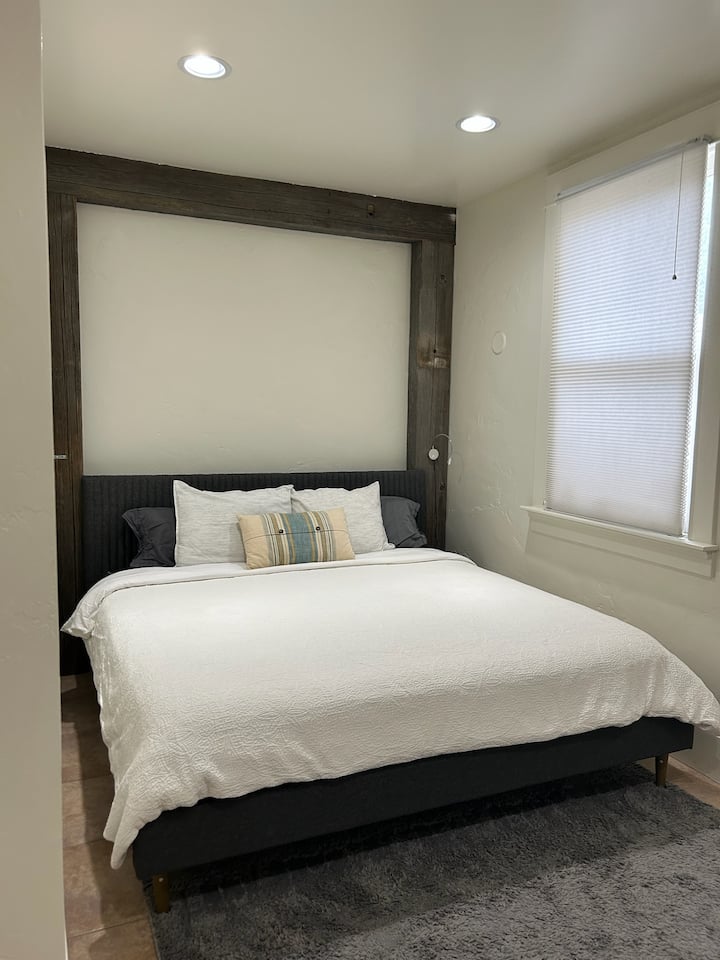 Amplio dormitorio con cama tamaño king, sábanas suaves y un diseño sereno para una noche de sueño tranquilo.