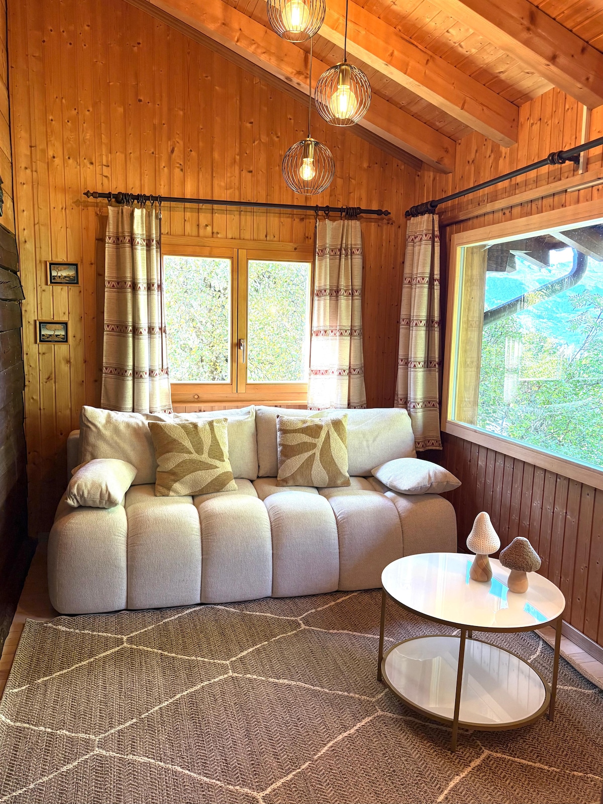 Sala de estar cálida, bañada en luz con vistas a la naturaleza, sofá acogedor y ambiente acogedor ideal para relajarse.
