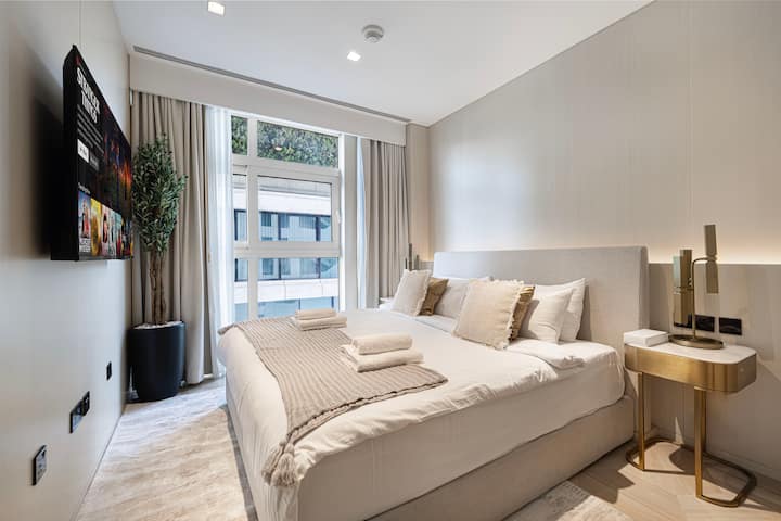 חדר שינה אלגנטי עם מיטת קינג סייז, מצעים יוקרתיים. חוויית נוחות של 5 כוכבים במרחק צעדים ספורים מאטלנטיס רויאל, פארק המים אקוואוונצ'ר וחיי הלילה של מרינת דובאי.