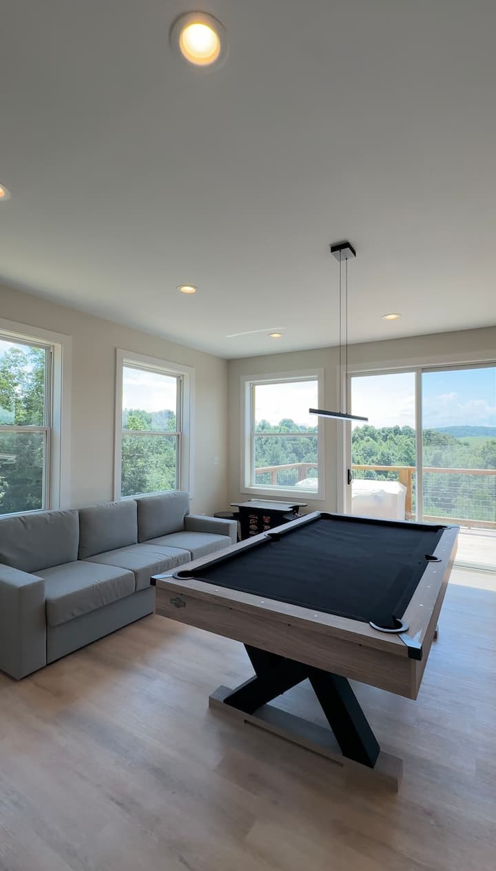 明亮的游戏室，景色迷人，配备时尚的台球桌和舒适的沙发，可转换成标准双人床，非常适合娱乐、放松和额外的睡眠空间。