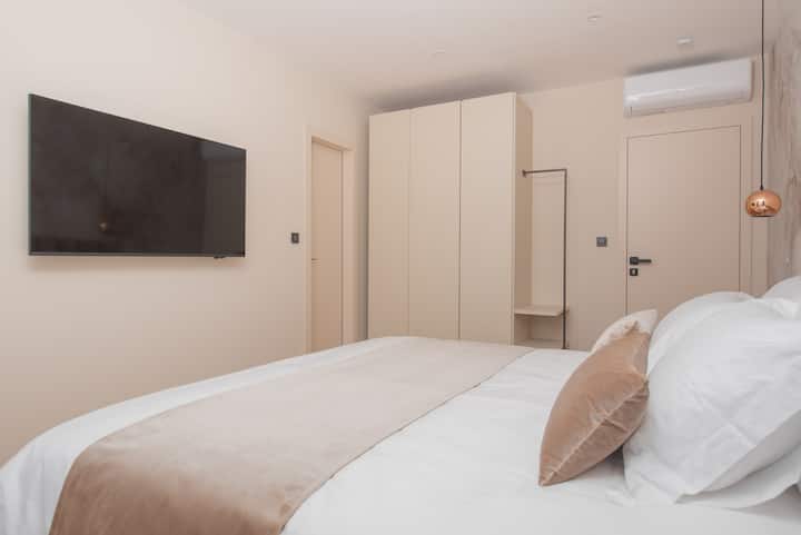 Dormitorio 5: tranquilo y moderno con una cama tamaño king, soluciones integradas de alta calidad y una vista del paisaje.