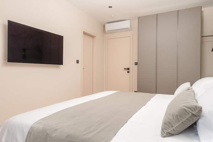 Dormitorio 3: elegante habitación doble con cama tamaño king y gran ventana con vistas al mar y al jardín.