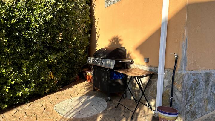 Zona de jardín con barbacoa y mesa junto a la casa: perfecta para las comidas al aire libre.