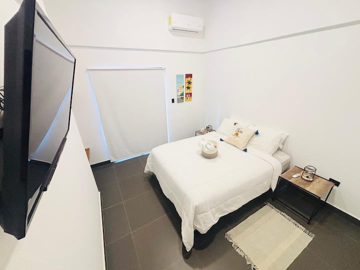 Chambre principale avec lit double, climatisation et télévision