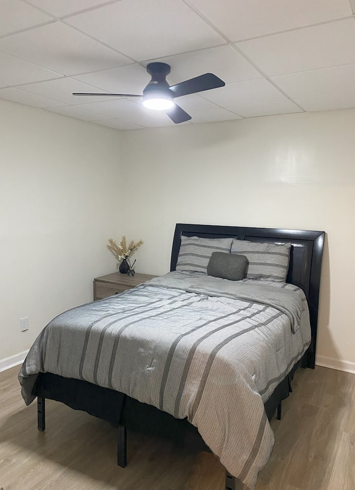 Chambre lumineuse, propre et minimaliste avec un grand lit et des draps doux. Ventilateur de plafond à intensité variable. 