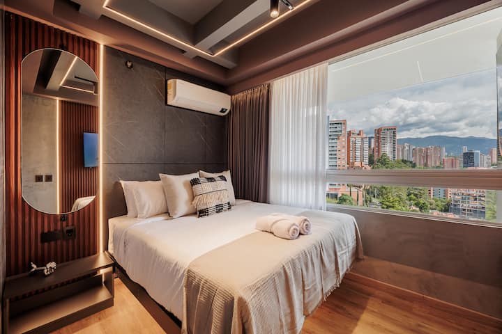 Acogedora habitación con cama tamaño queen, Smart TV, aire acondicionado y amplio armario. Una gran ventana da a la terraza privada, llenando la habitación de luz natural y aire fresco, creando un ambiente relajante para un sueño reparador.