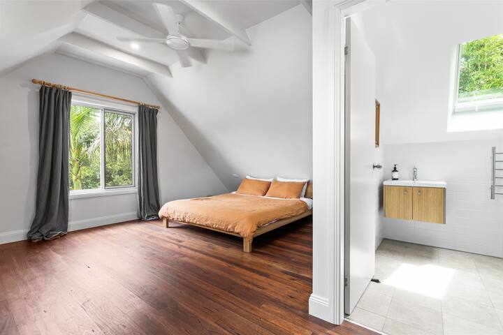 Chambre principale spacieuse à l'étage, avec climatisation et salle de bains privative. 