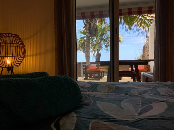 La habitación de la planta baja tiene acceso directo a la terraza con una magnífica vista al mar. Amplia y luminosa, está equipada con una cómoda cama y prácticos espacios de almacenamiento.