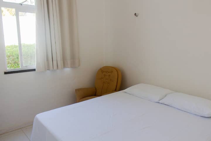 Chambre au rez-de-chaussée, lit queen size, avec rideaux/occultants, un fauteuil, ventilateur.  
Crochets (supports) disponibles pour un hamac!
Toilettes et salle de bain sociale accessible à côté de la chambre.
Vue jardin.
