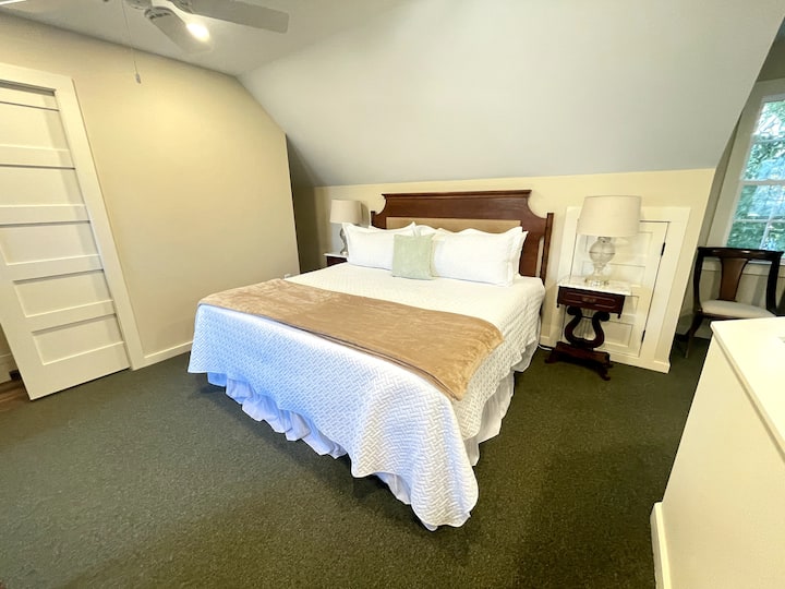 Loft apartman s bračnim krevetom i prostorom za sjedenje s pogledom na sjajnu sobu.