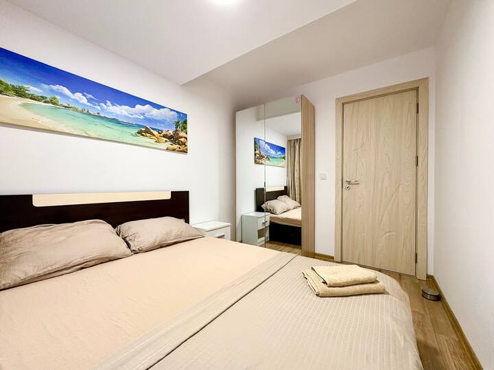 Spálňa s manželskou posteľou, šatníkom a obrazom na stene. Priestranná a svetlá izba, ktorá vytvára útulnú a príjemnú atmosféru, ideálna pre pohodlný pobyt a plnohodnotnú dovolenku.