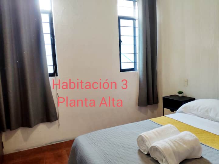 Spálňa 3 na poschodí, umiestnená na konci chodby, so zatemňovacími závesmi, ventilátorom, stolom, nábytkom na oblečenie, odpadkovým košom a ďalšími uterákmi a prikrývkami v terakotovej skrini 