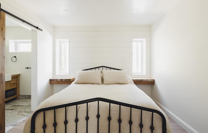 Bedroom #1 - Main floor of the cottage featuring one queen bed with a ensuite stand up shower layout. 