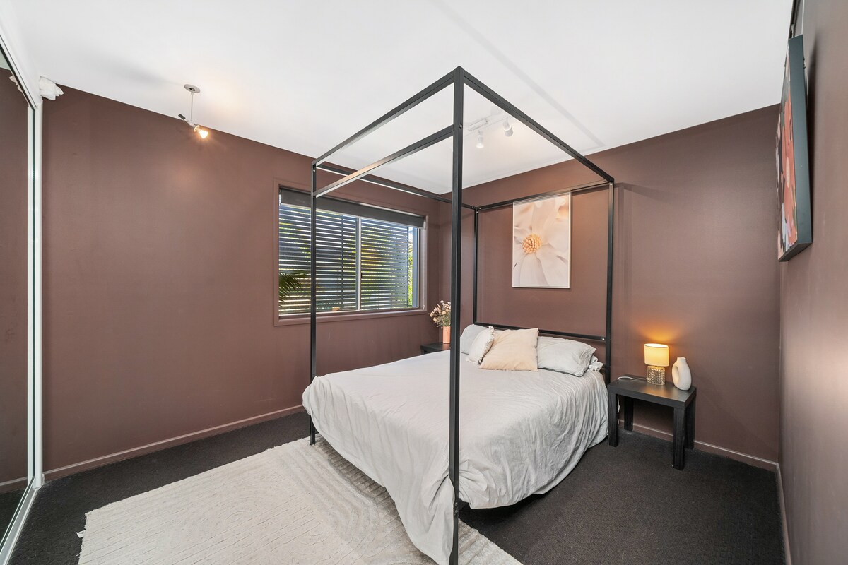 Deuxième chambre accueillante avec un lit à baldaquin élégant et un décor apaisant.