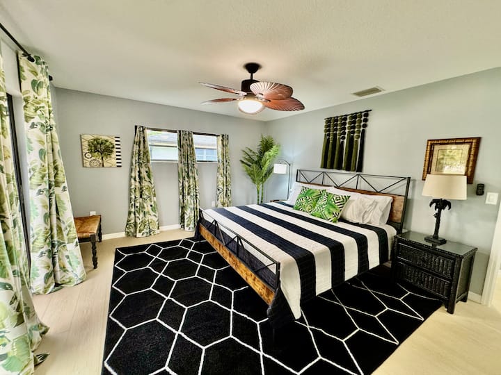 غرفة واسعة مع سرير بمقاس كينج وحمام وأبواب منزلقة كبيرة تواجه القناة.