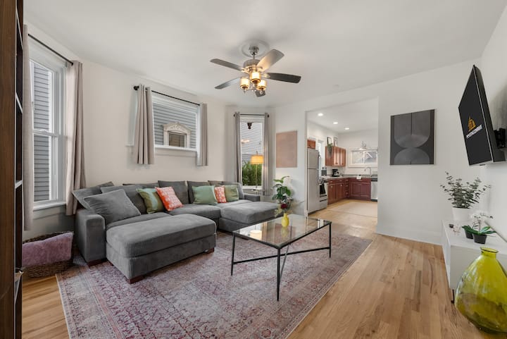 غرفة معيشة مشرقة وجيدة التهوية في الطابق الأول مع أريكة كبيرة تتضاعف كمساحة نوم أخرى، وتلفزيون روكو الذكي، والكثير من الضوء الطبيعي. مسكن مريح وحديث للاسترخاء والاستمتاع بإقامتك.