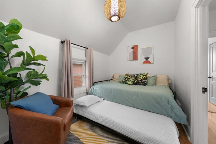 غرفة نوم مريحة في الطابق الثاني تتميز بسرير نهاري بحجم كوين مع مرتبة فردية قابلة للسحب تحته لمساحة نوم إضافية. ملاذ لطيف ومريح مثالي للاسترخاء بعد يوم حافل.