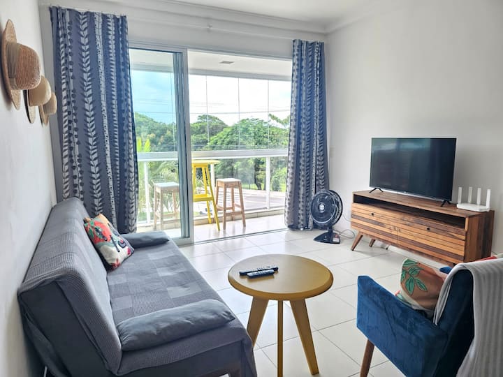 Уютна всекидневна със смарт телевизор и изглед към морето от балкона