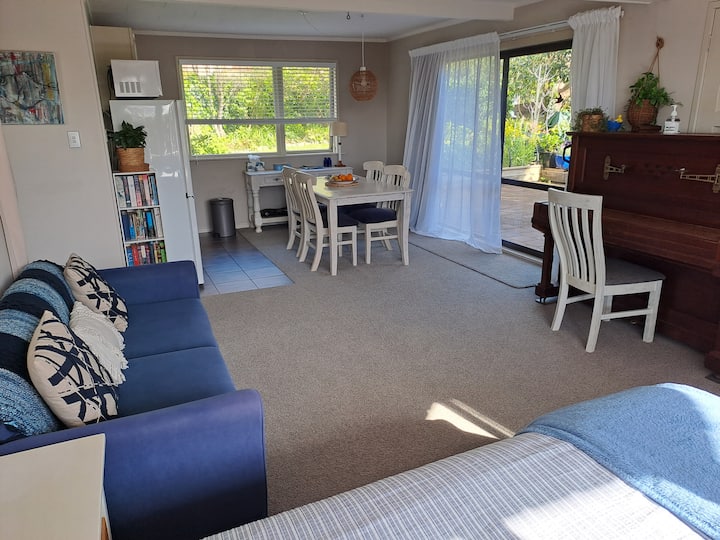 Kuangalia eneo la kula na chumba cha kupikia pamoja na mlango mkuu wa kuingia unaoteleza.  Mionekano ya bustani ya nje.