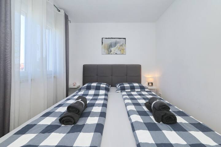 卧室干净简约，配有标准双人床、柔软的格纹床上用品，自然采光充足。 放松身心的宁静舒适度假胜地。
