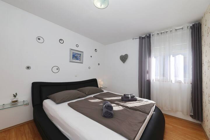 明亮舒适的主卧，配备现代双人床、柔和照明和遮光帘。 一个宁静的空间，专为宁静的夜晚和放松的早晨而设计。
