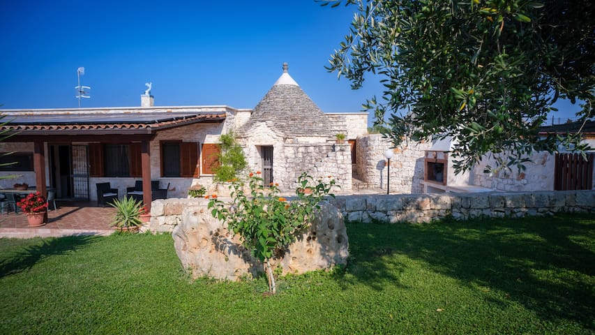 Trullo e casa in pietra con piscina e ulivi