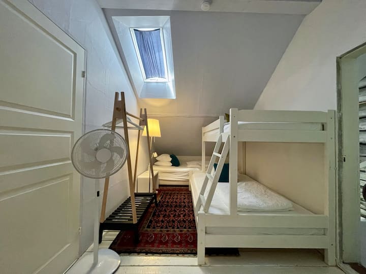 Sovrum 4 med en enkelsäng i övre våningssäng, en stor enkelsäng i nedre våningssäng och en andra stor enkelsäng. 