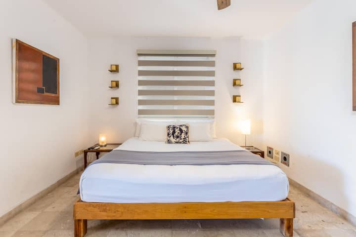 Chumba cha kulala cha ghorofa ya chini chenye televisheni ya inchi 65.