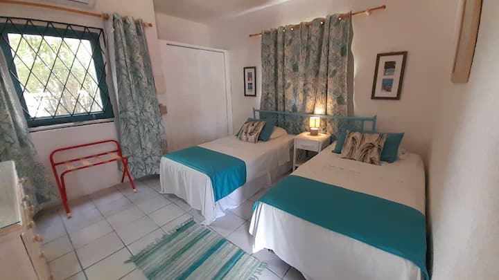 Udobna spavaća soba s klima-uređajem i dva odvojena kreveta za fleksibilan raspored spavanja.