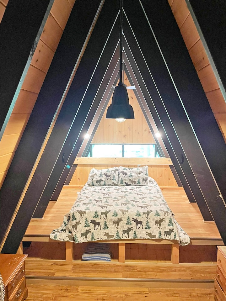 Horná podkrovná spálňa s vyvýšenou manželskou posteľou (k dispozícii sú vankúše a posteľná bielizeň).