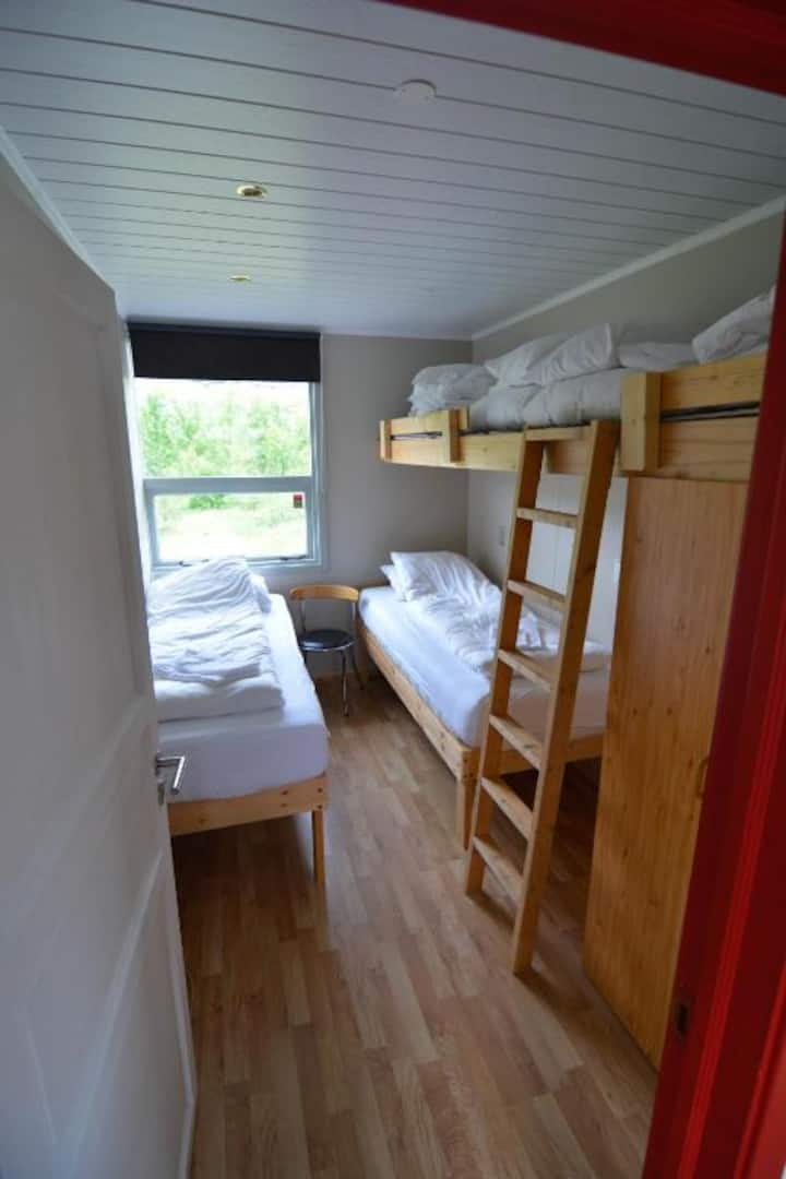 Sur la photo, comme vous pouvez le voir, il y a deux lits simples séparés et un lit superposé. Cependant, la couchette supérieure n'est pas utilisée. Il est utilisé pour la literie et les oreillers. Cette chambre dispose de deux lits simples à utiliser.