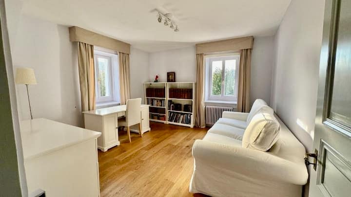 Habitación luminosa y versátil con un acogedor sofá cama y escritorio, ideal como una oficina tranquila o un dormitorio adicional.