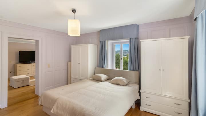 Dormitorio en la planta superior con una cama tamaño king, luz natural y una vista tranquila, iluminada suavemente para noches acogedoras.