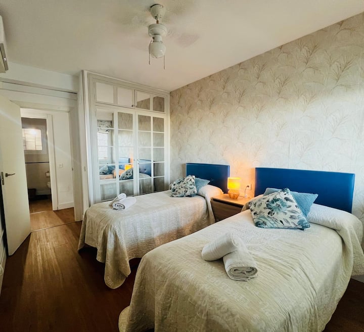 Pohodlná spálňa s dvoma lôžkami a výhľadom na oceán, klimatizáciou, stropným ventilátorom, nepriehľadnými schodmi, televízorom a trezorom v skrini